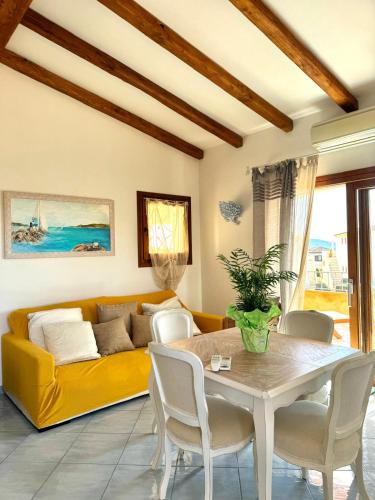 a living room with a yellow couch and a table at Terezza Alba in Cannigione