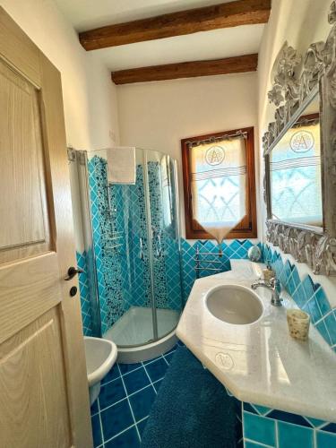 a blue tiled bathroom with a sink and a shower at Terezza Alba in Cannigione