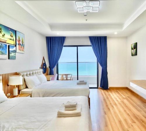 a hotel room with two beds and a large window at FLC Sea Tower Quy Nhơn__Du Lịch Bình Định in Quy Nhon