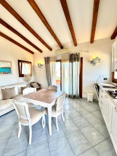 a kitchen and living room with a table and chairs at Terezza Alba in Cannigione