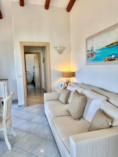 a living room with a white couch and a painting at Terezza Alba in Cannigione