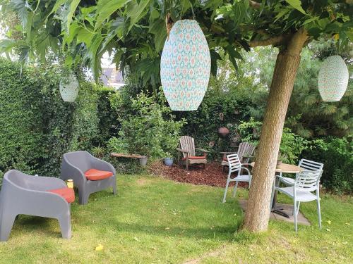a group of chairs and a table under a tree at B&B De Wadvaarder in Midsland