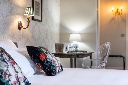 a bedroom with a bed with pillows and a table at Hôtel de la Poste à Avallon, Bourgogne in Avallon