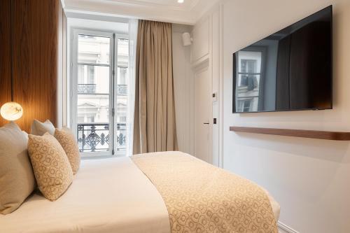Cette chambre comprend un lit et une télévision à écran plat. dans l'établissement TheLander - Serviced Apartments in Opéra, à Paris