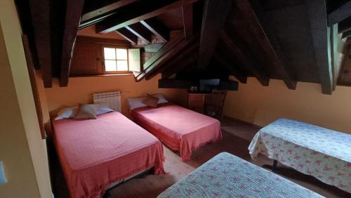 a room with two beds and two tables and a window at Trisileja Posada El Manjon in Barros