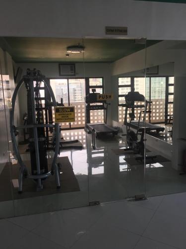 a gym with several tread machines and a mirror at Modern Studio Gem - Two Balconies with Ocean & Mountain Views in Cebu City