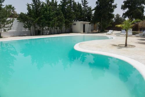 a swimming pool with blue water in a resort at Chalet El Molino in Chiclana de la Frontera