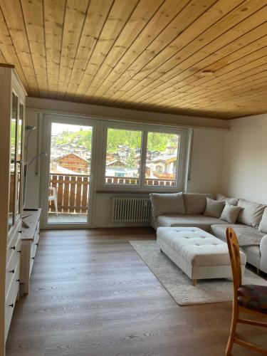 a living room with a couch and some windows at Sonniges Apartment im Zentrum mit Bergblick in Grächen