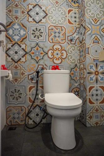 a bathroom with a toilet and a wall at Gypsy Lust Ubud in Ubud