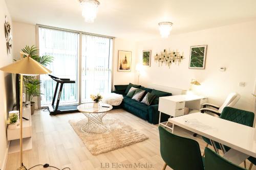 a living room with a green couch and a table at Cozy Haven Flat in Milton Keynes