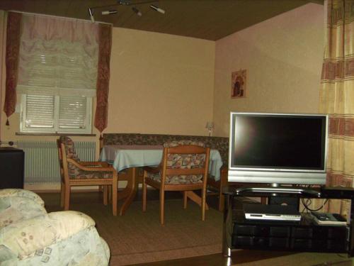 a living room with a television and a table with chairs at Ferienhaus Reinhold Betz in Beilngries
