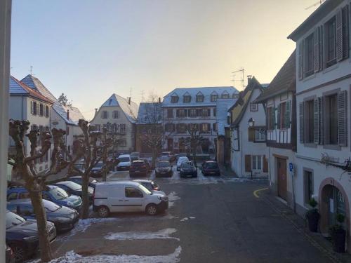 a city street with parked cars and buildings at Studio Avalon I in Ribeauvillé