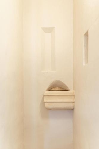 a white wall with a shelf in a room at Palazzo Zimara Boutique Hotel in Lecce