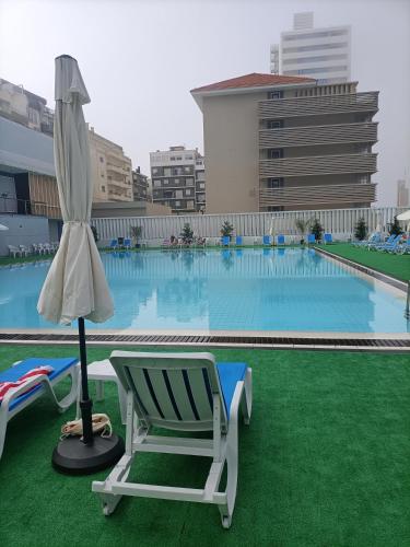 a chair and an umbrella next to a swimming pool at New Wave "The best place" in Figueira da Foz
