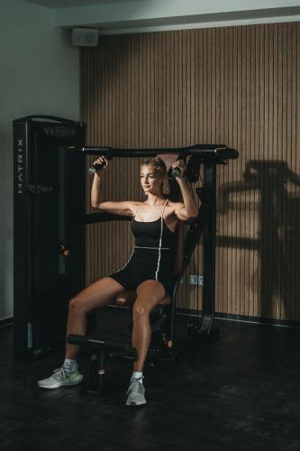 a woman is sitting on a bar in a gym at Hotel Eibl-Brunner 4-Sterne-Superior in Frauenau