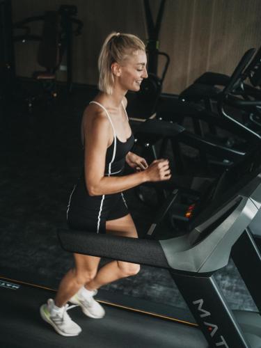 a woman running on a treadmill in a gym at Hotel Eibl-Brunner 4-Sterne-Superior in Frauenau