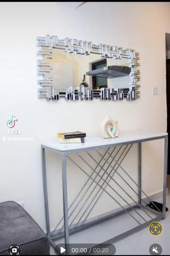 a table with a mirror on a wall at Luxore appartments in Nairobi