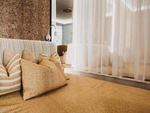 a couch with pillows on it in a living room at Hotel Eibl-Brunner 4-Sterne-Superior in Frauenau