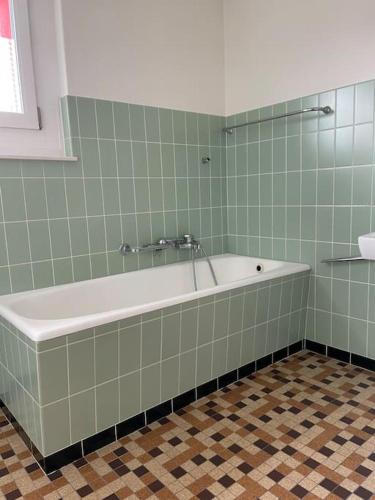 a bath tub in a bathroom with green tiles at NH 5 Interlaken-Luzern I Lake I Mountain I connect in Sachseln