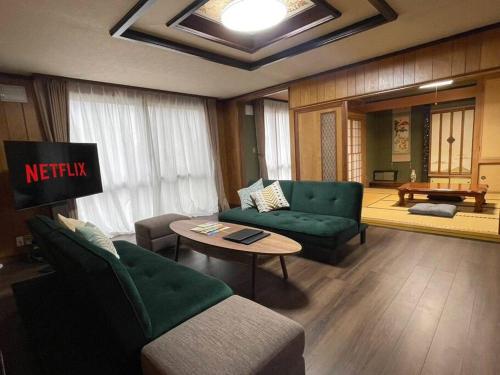 旭川市にあるHarry's Ski House ASAHIKAWAのソファとテーブルのあるリビングルーム
