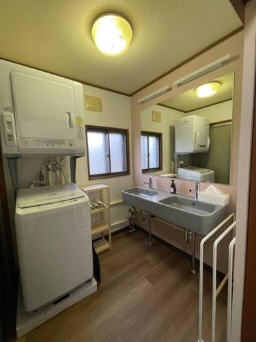 a bathroom with two sinks and a large mirror at Harry's Ski House ASAHIKAWA in Asahikawa