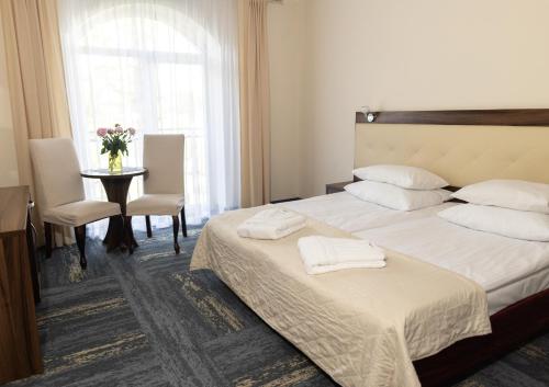 a hotel room with two beds and a table at Hotel Woiński Spa in Lubniewice