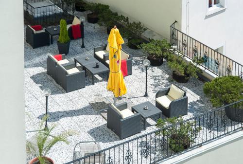 a patio with chairs and a yellow umbrella at Hotel Europa in Görlitz