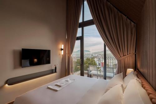 a hotel room with a bed with a large window at Adela Villa Dalat in Khu Chi Lăng