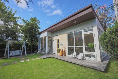 a house with two chairs and a yard at OwlStay Green Villa in Pinghe