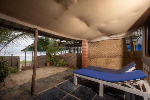 a porch with a blue bed and a view of the ocean at Talpona Beach Studios in Canacona