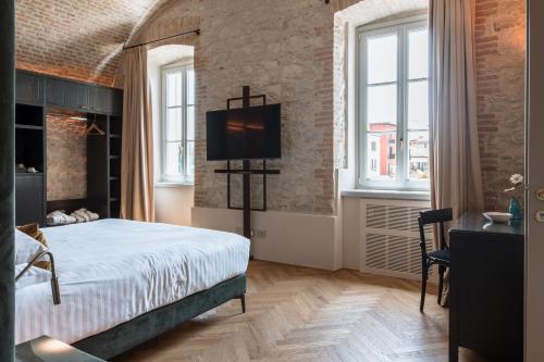 a bedroom with a bed and a tv on the wall at Pavillon Suite in Peschiera del Garda