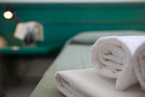 sterta ręczników na stole w obiekcie Hotel Miralonga w mieście La Maddalena