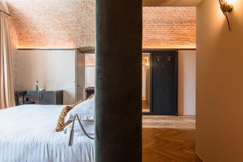 a bedroom with a bed and a brick wall at Pavillon Suite in Peschiera del Garda