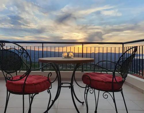 a table and two chairs on a balcony with a view at Ithaki House in Lyso