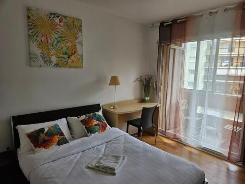 une chambre avec un lit, un bureau et une fenêtre dans l'établissement Le Tolstoï chic, à Villeurbanne