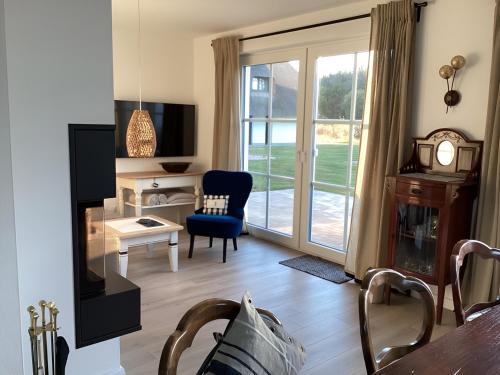 een woonkamer met een tafel en een stoel en een raam bij Haffkoje - Ferienhaus mit Kamin und Sauna für 6 Personen in Pepelow