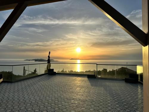 a view of the sunset from the balcony of a building at ClaudiAgapi Apartments Korfu in Agios Stefanos