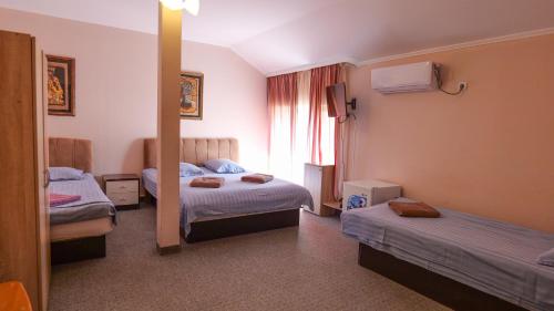 a hotel room with two beds and a mirror at Pensiunea La Luna in Negreşti-Oaş