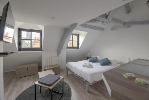 une chambre avec un lit et une table dedans dans l'établissement L'Authentique, à Rennes