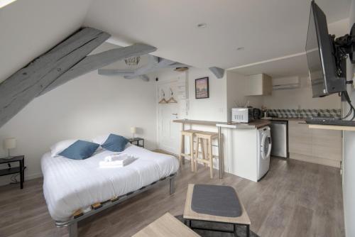 une chambre avec un grand lit et une cuisine dans l'établissement L'Authentique, à Rennes