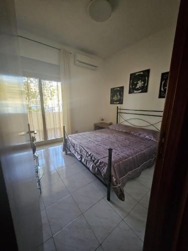 a bedroom with a bed and a large window at Don Vladi in Letojanni