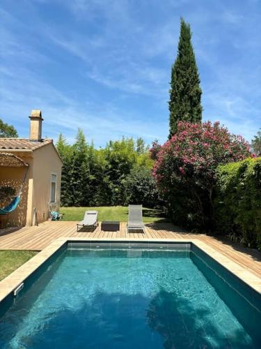 - une piscine dans une cour avec 2 chaises dans l'établissement Villa piscine Gorges d'Ardèche, à Pont-Saint-Esprit