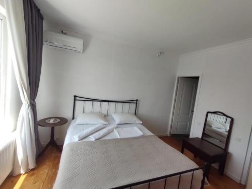 a bedroom with a bed and a table and a window at Book wine tasting over Tbilisi in Tbilisi City