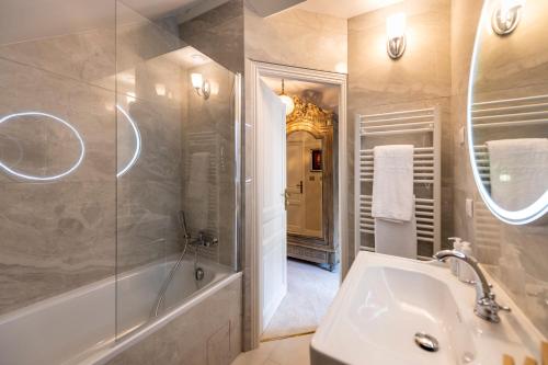 a bathroom with a tub and a sink and a shower at Hôtel de la Poste à Avallon, Bourgogne in Avallon