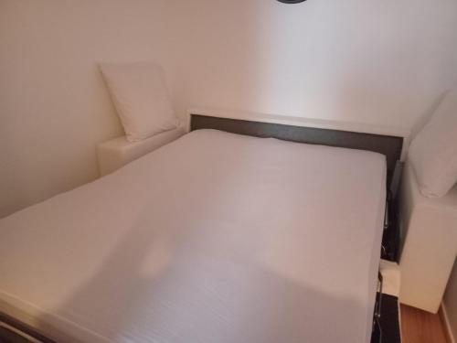 a small bedroom with a white bed in it at Le King & Suites étoilées in Gréoux-les-Bains