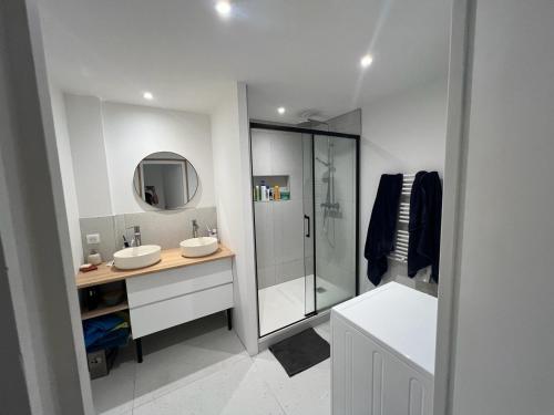 une salle de bain blanche avec deux lavabos et une douche dans l'établissement Grand Appartement centre, à Bayonne