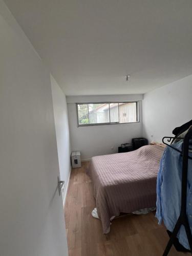 une petite chambre avec un lit et une fenêtre dans l'établissement Grand Appartement centre, à Bayonne