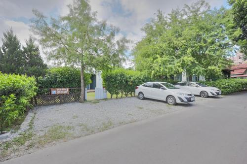 a couple of cars parked in a driveway at OwlStay Green Villa in Pinghe