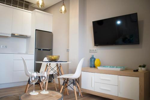 a kitchen with two chairs and a tv on the wall at TC Lindamar in Las Palmas de Gran Canaria