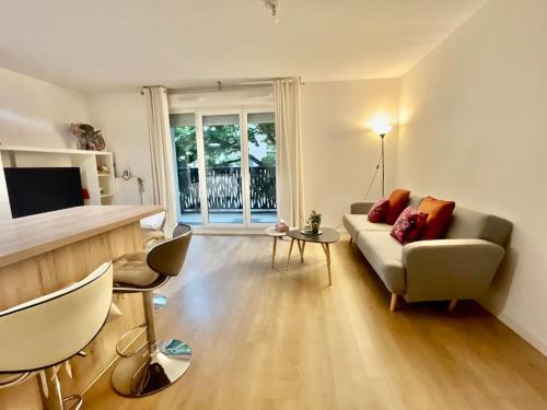 un salon avec un canapé et une table dans l'établissement Location appartement ou chambre à 25 min de Paris, à Villemomble